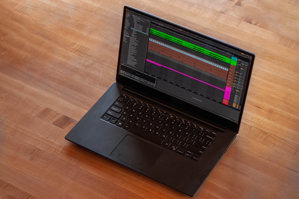 black laptop computer on brown wooden table