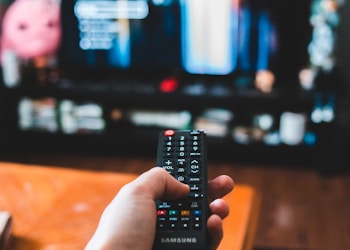 person holding black remote control