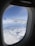 A happy traveler enjoying a scenic view from an airplane window.