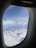 A happy traveler enjoying a scenic view from an airplane window.