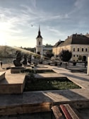 A faded photograph of a forgotten town square, bathed in golden afternoon light.