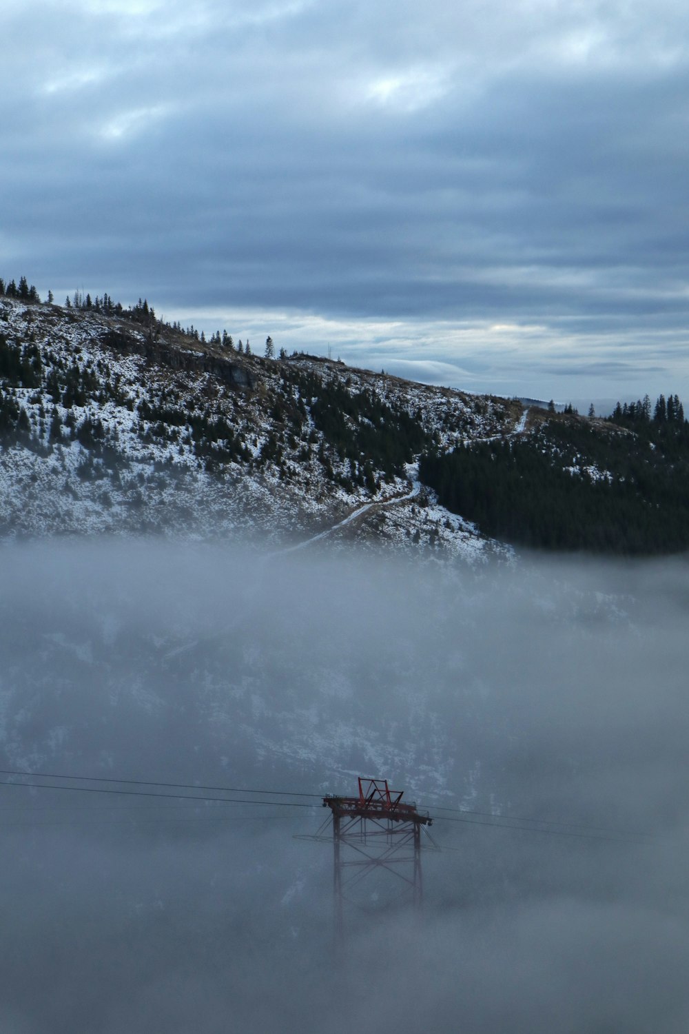 red cable car over snow covered mountain