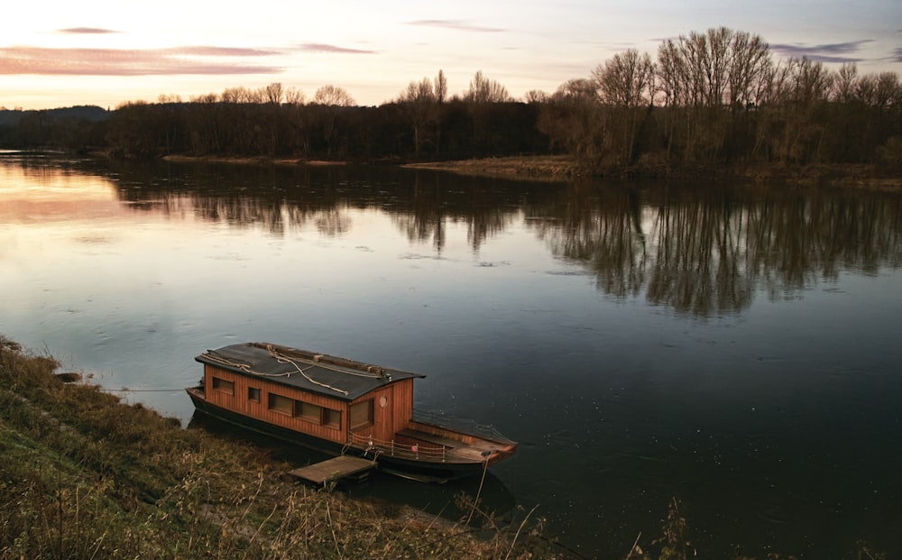 brown wooden boat on lake during daytime