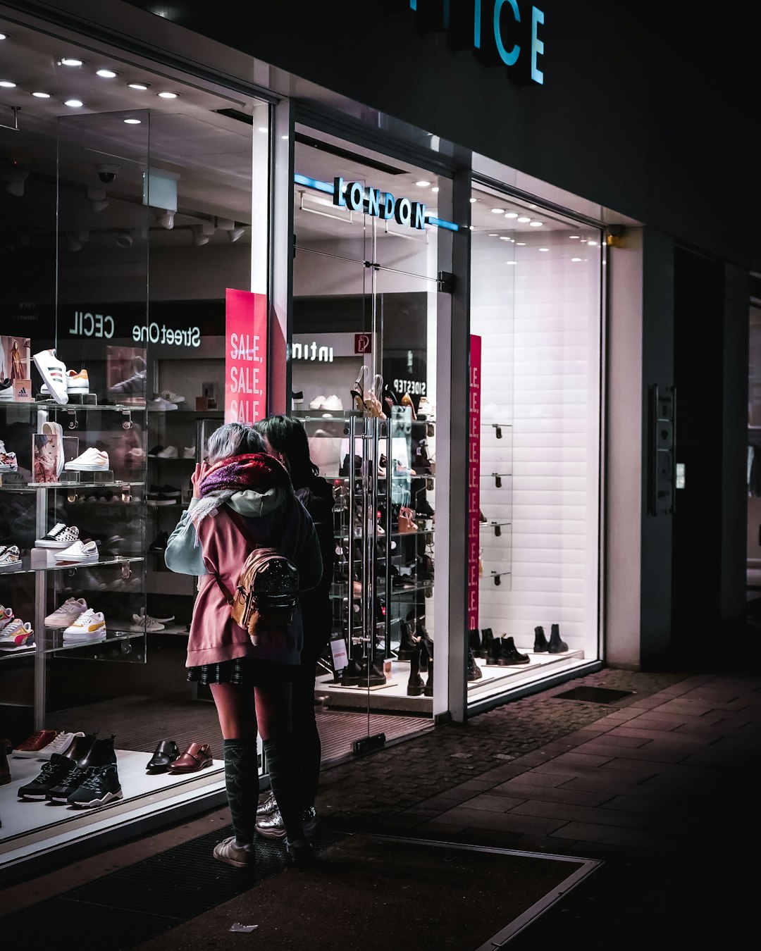 woman in black and white plaid coat standing near store