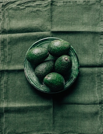 black round fruits in clear glass bowl