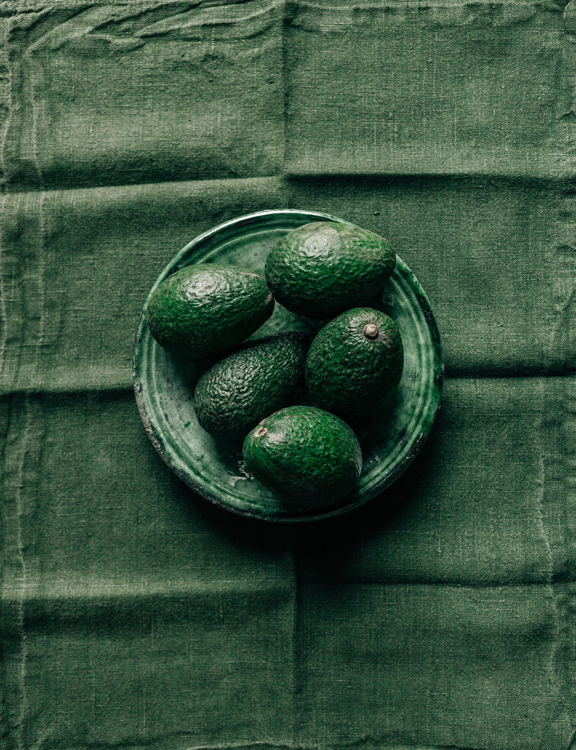 Avocados against Moroccan pottery and Japanese linens.