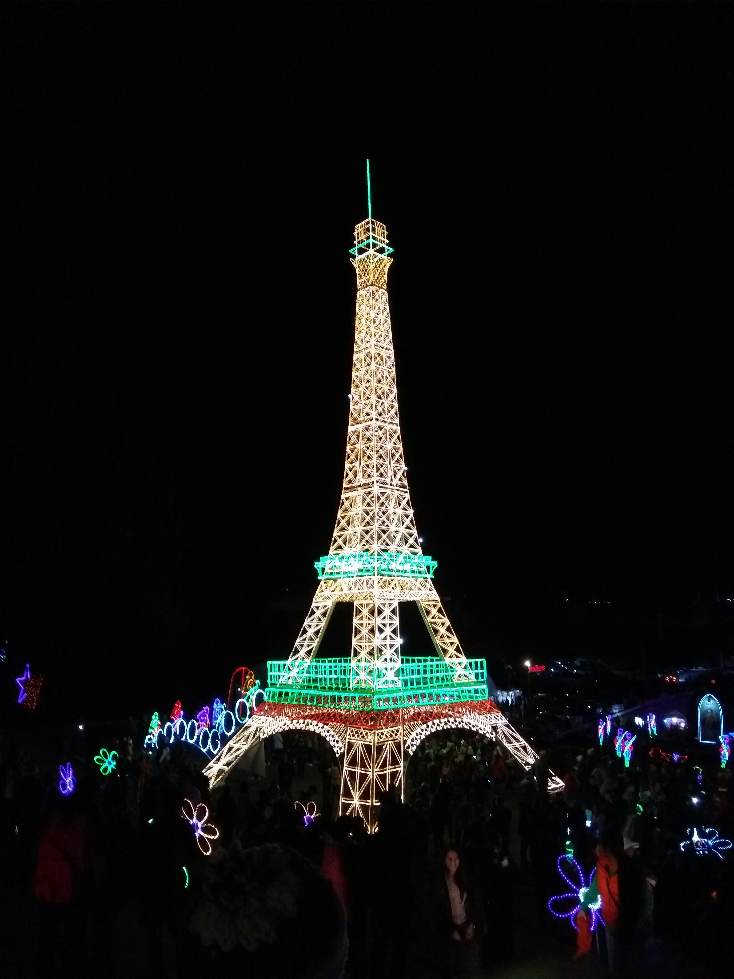夜のエッフェル塔のそばに立つ人々