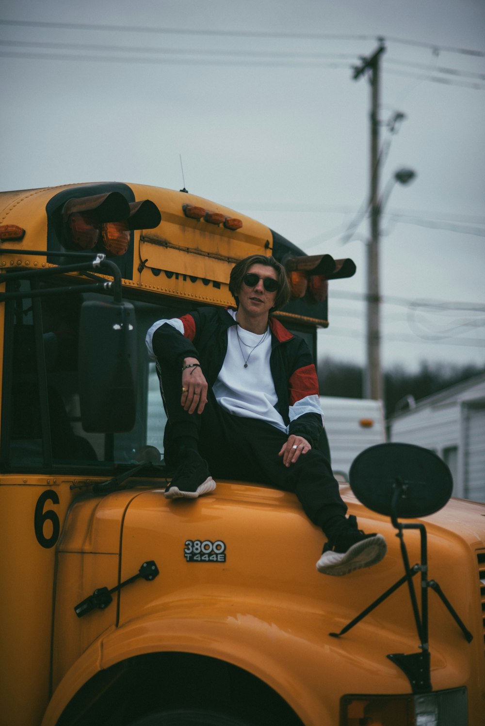 child in white and black jacket sitting on yellow school bus