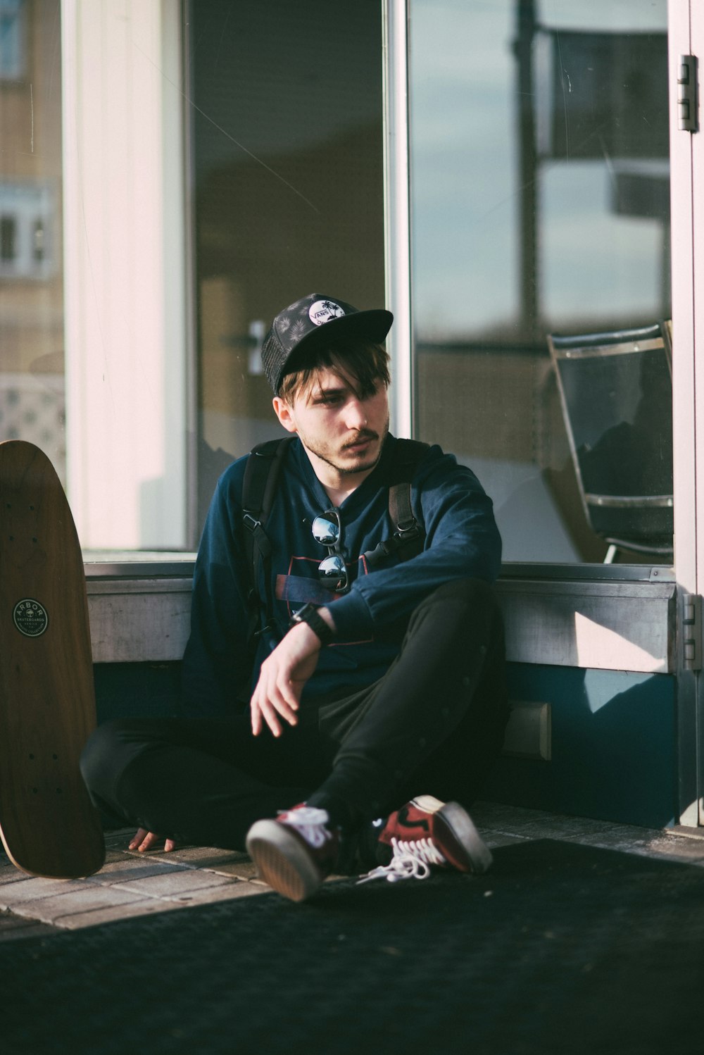 man in black jacket sitting on brown wooden chair