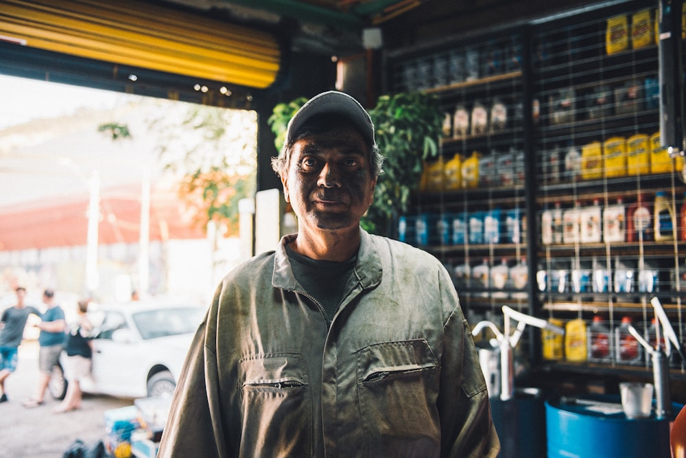 man in gray button up shirt wearing black cap