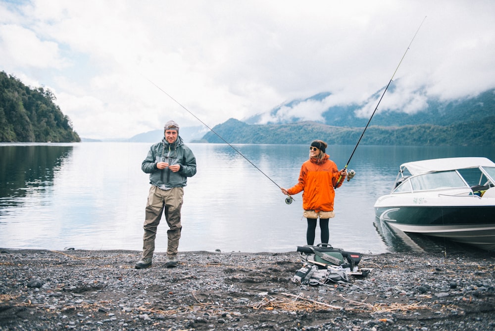 man in blue jacket and gray pants fishing on sea during daytime