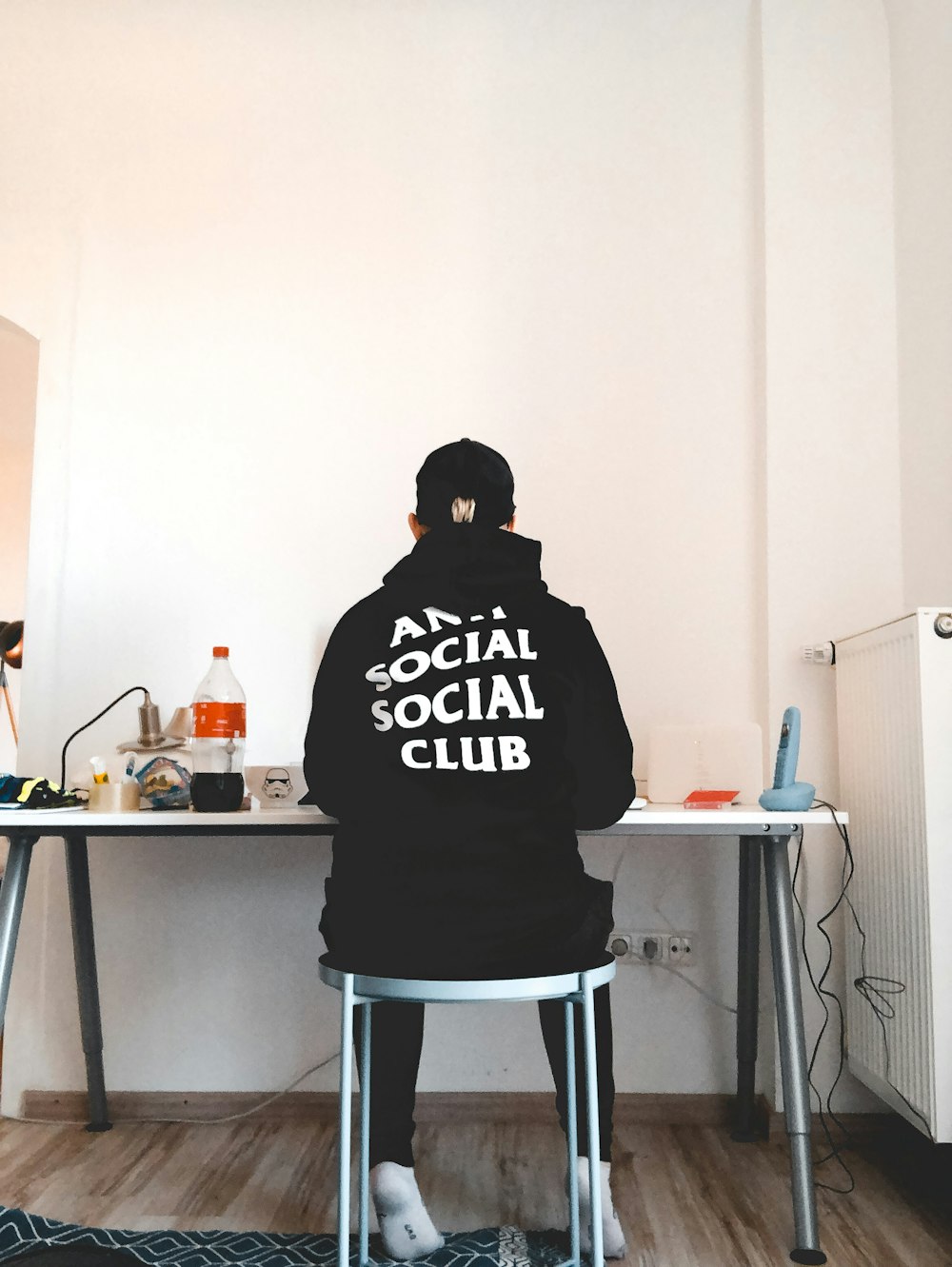 man in black and white hoodie sitting on chair