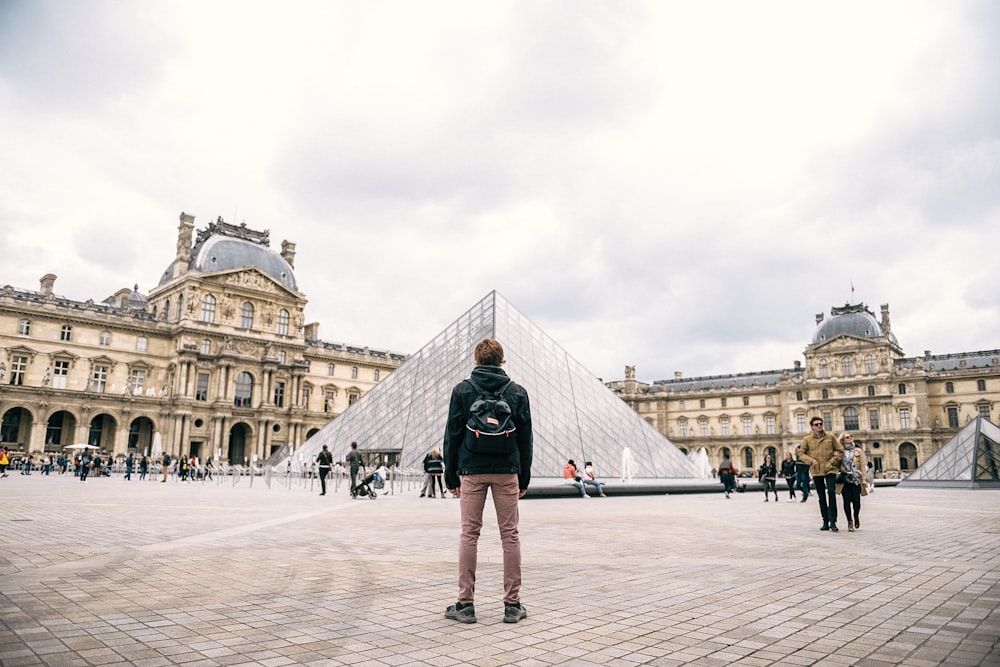 woman in black jacket standing on white concrete floor during daytime