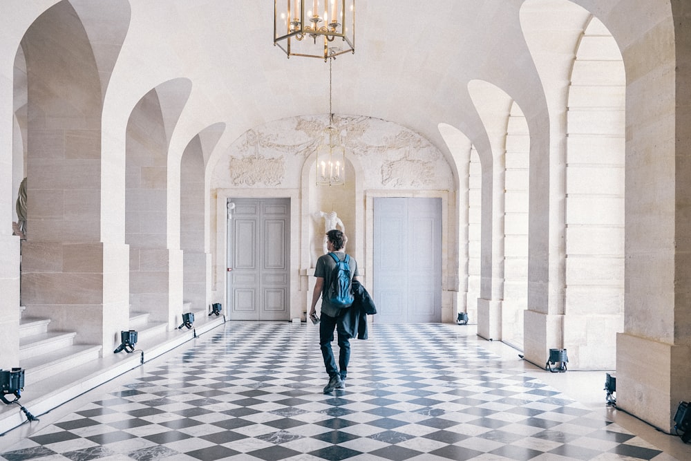 man in black jacket walking on hallway