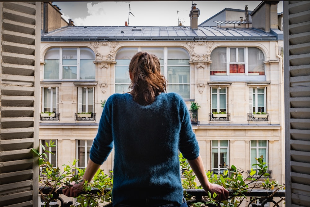 woman in purple long sleeve shirt and blue denim skirt standing near green plants during daytime