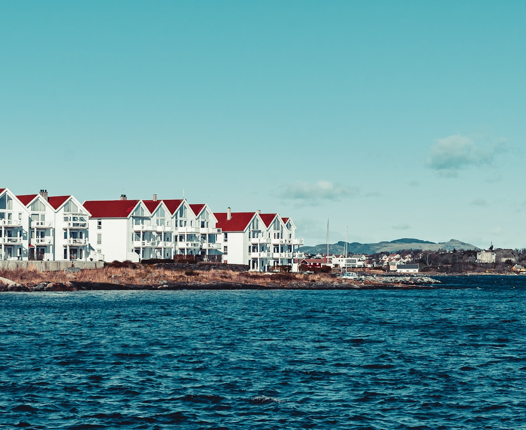 white and red concrete building near body of water during daytime