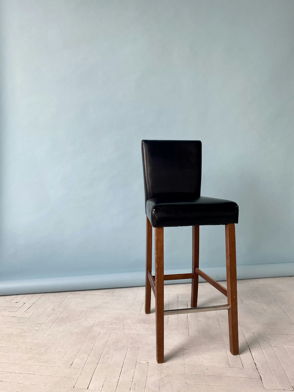 brown wooden chair beside white wall