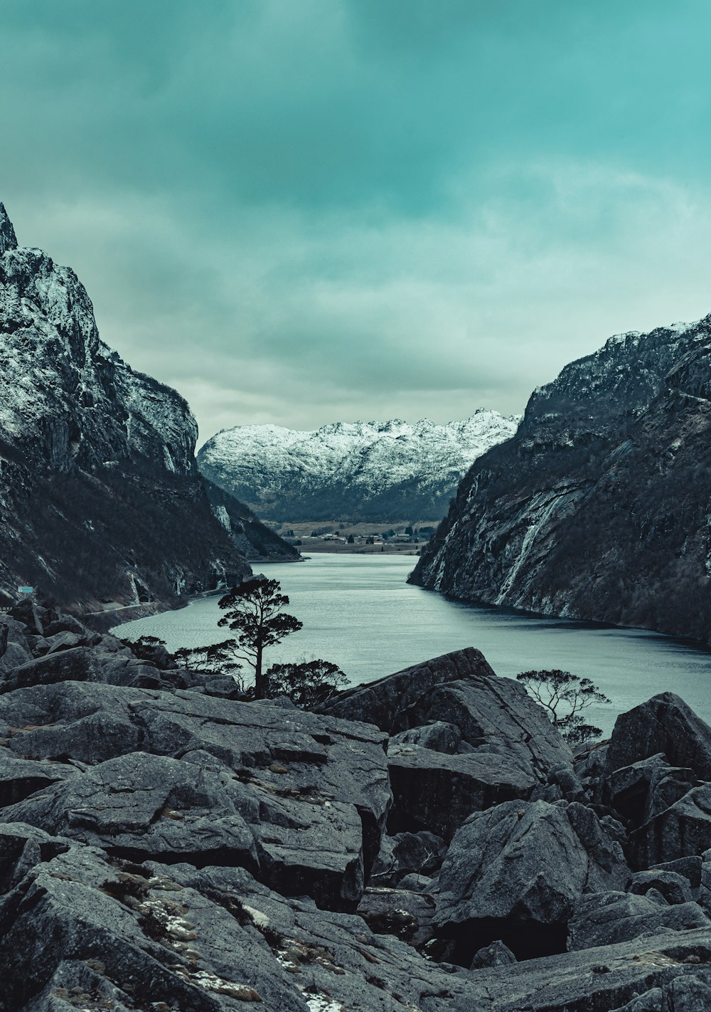 rocky mountain beside body of water during daytime