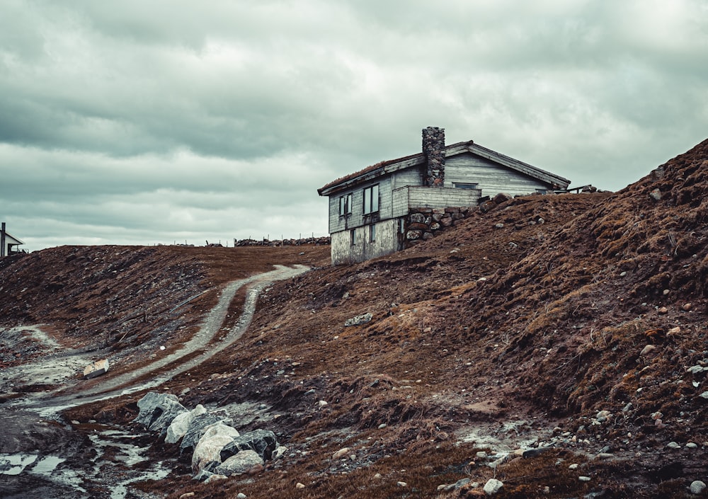 brown wooden house on brown grass field under cloudy sky during daytime