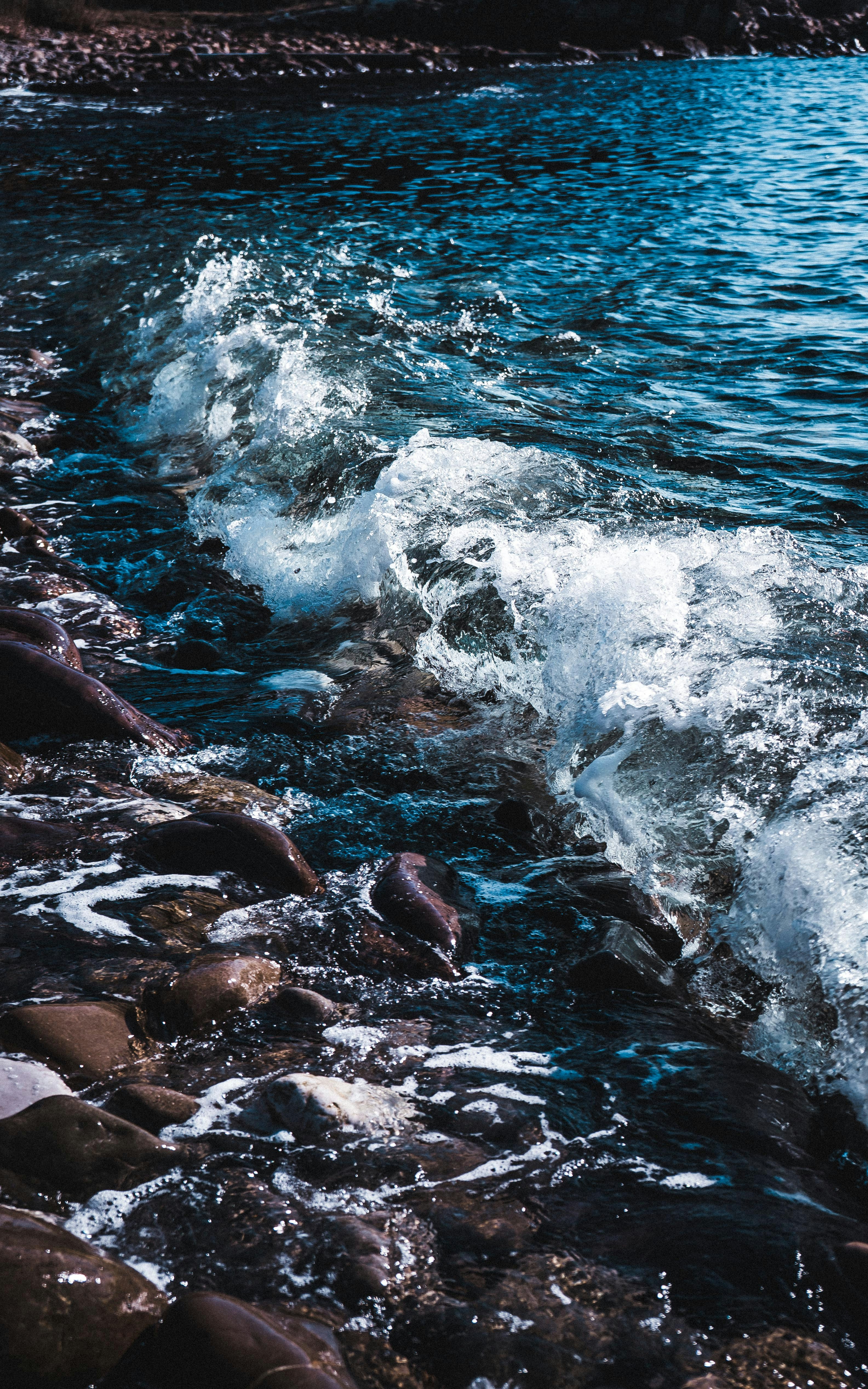brown rocks on body of water during daytime