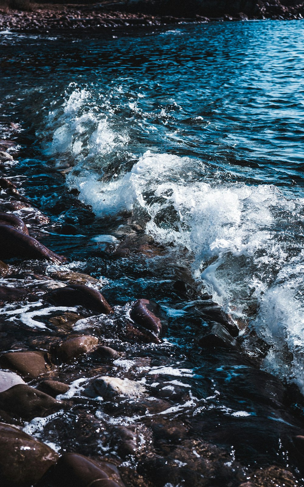 brown rocks on body of water during daytime