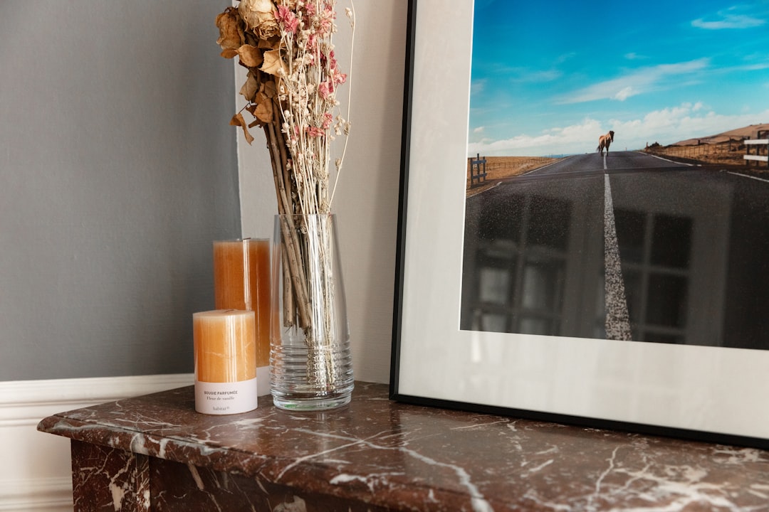 white ceramic mug beside clear glass vase on brown wooden table