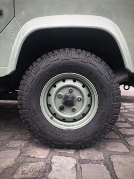 Close-up of a mechanic changing a car tire on the street.
