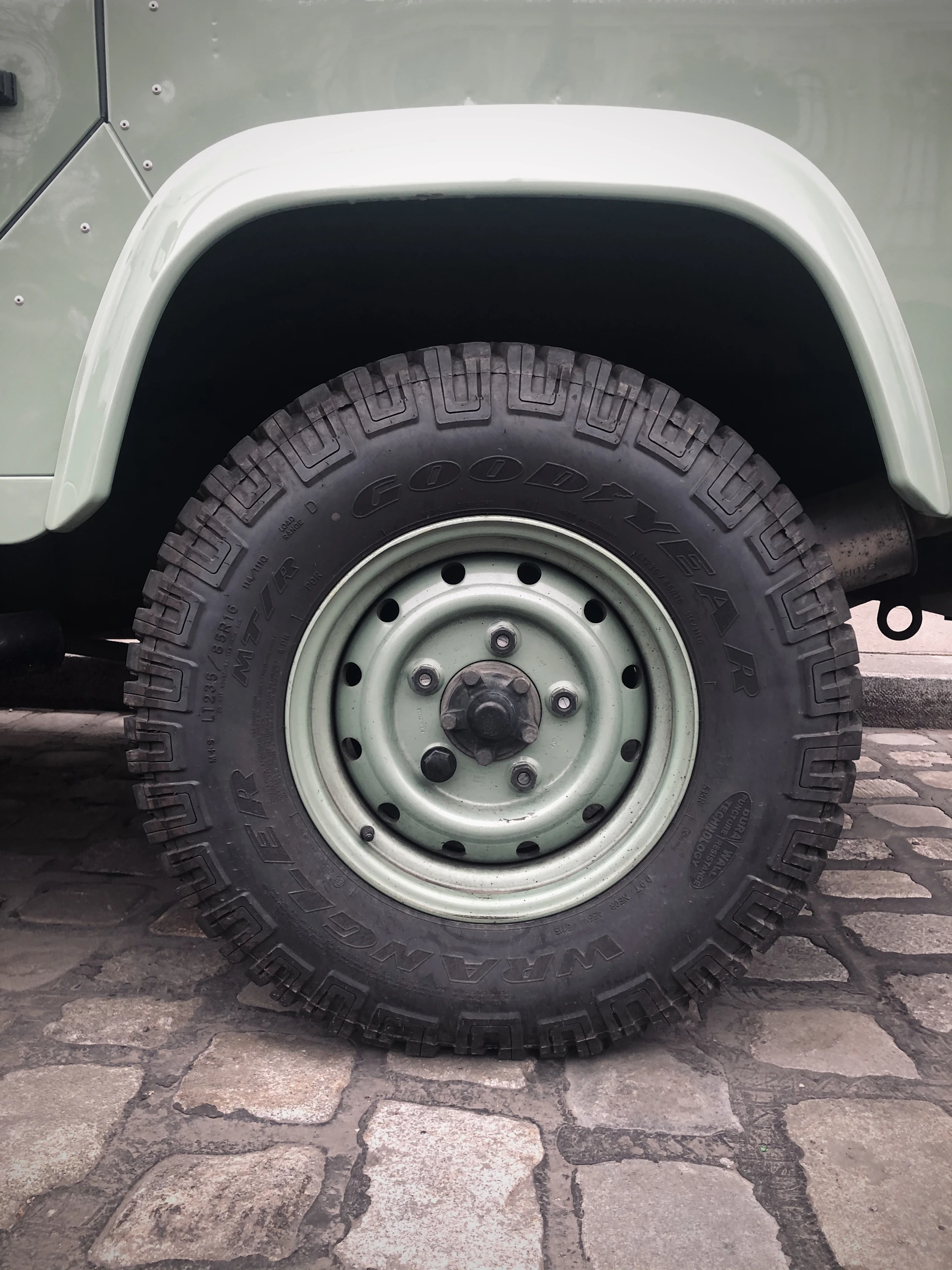 Close-up of a durable stroller wheel rolling smoothly over a cobblestone street.