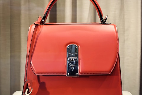 red leather handbag on white table