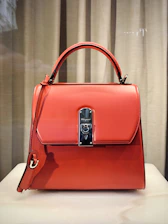 red leather handbag on white table