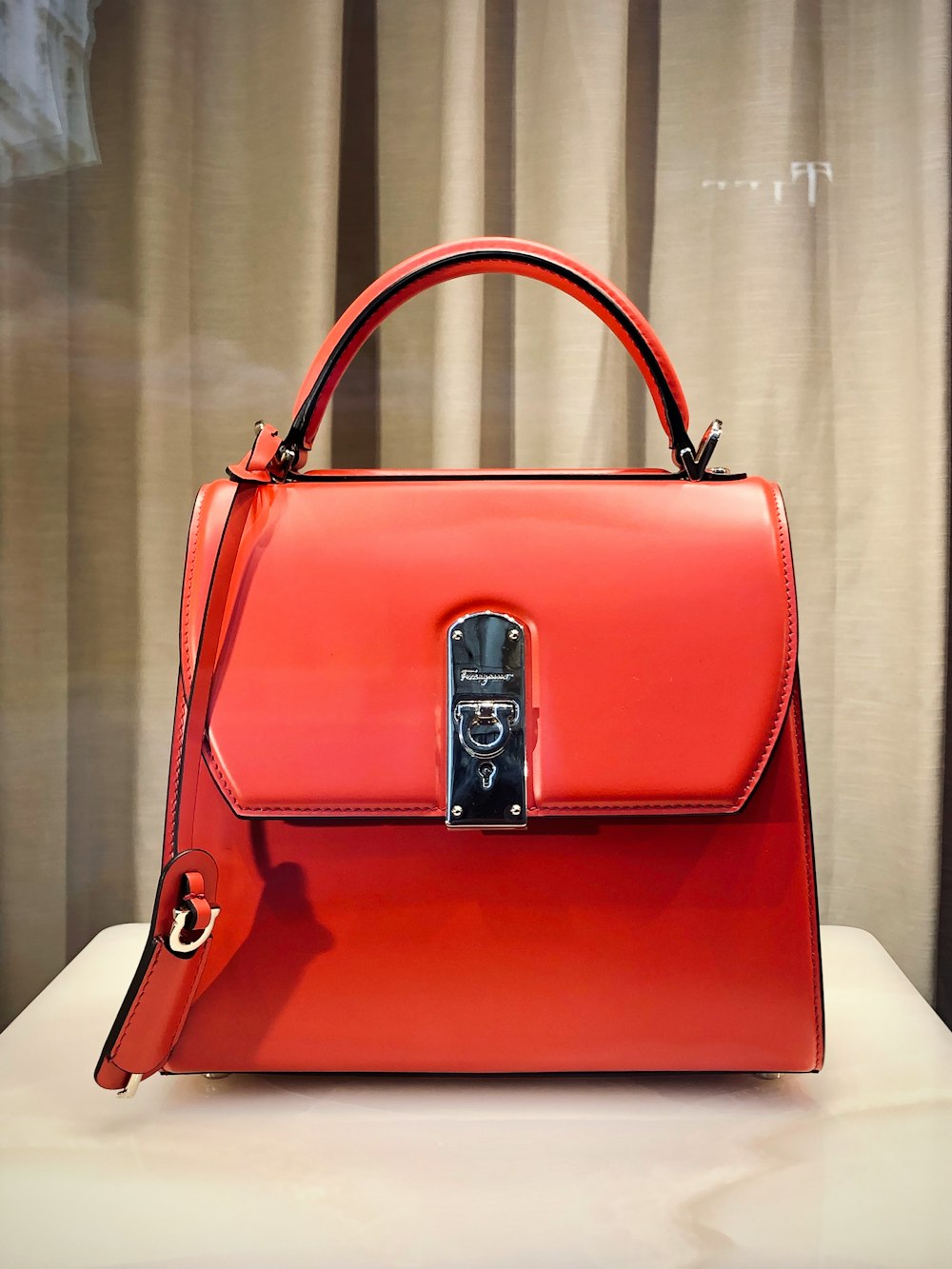 red leather handbag on white table