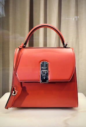 red leather handbag on white table