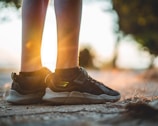 A close-up of trail running shoes on a dirt path.