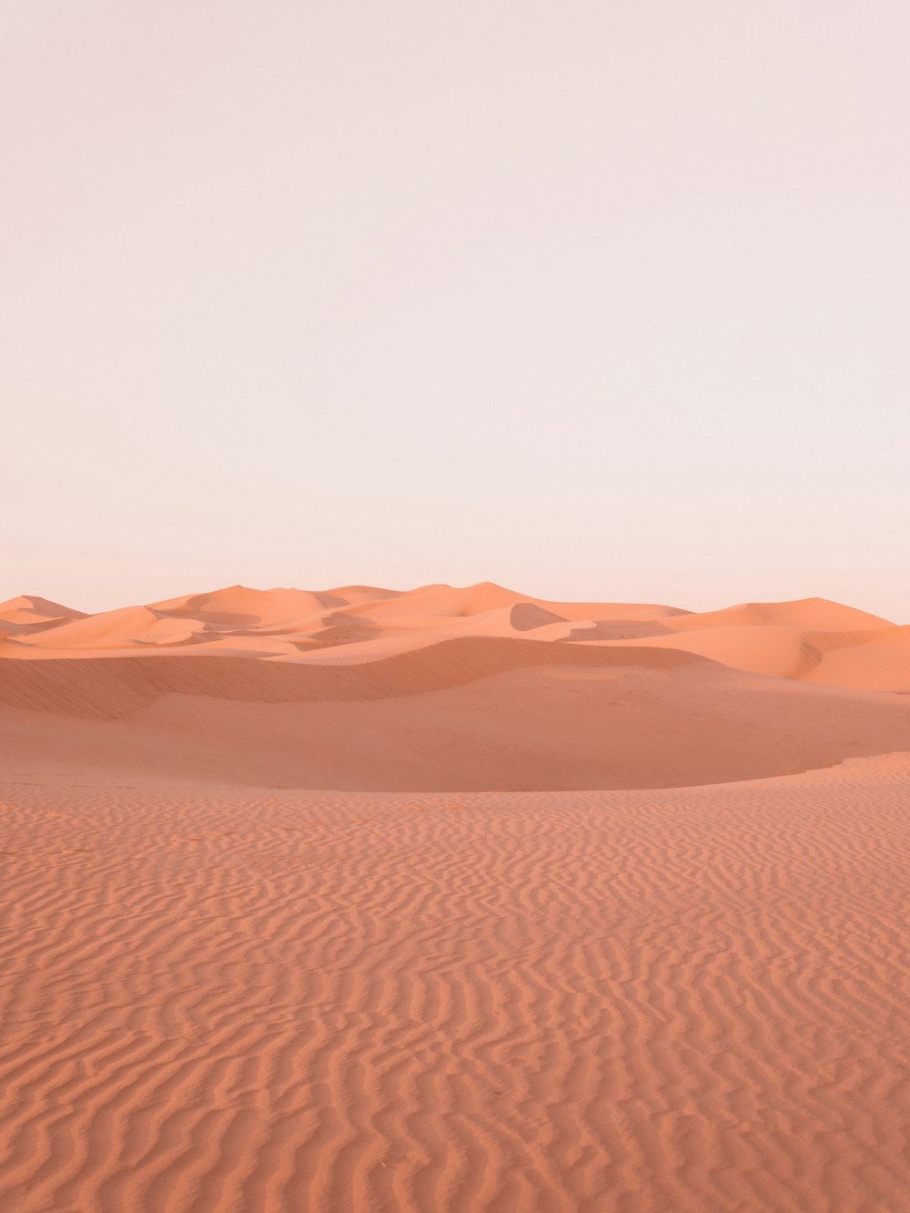 deserto marrone sotto il cielo bianco durante il giorno