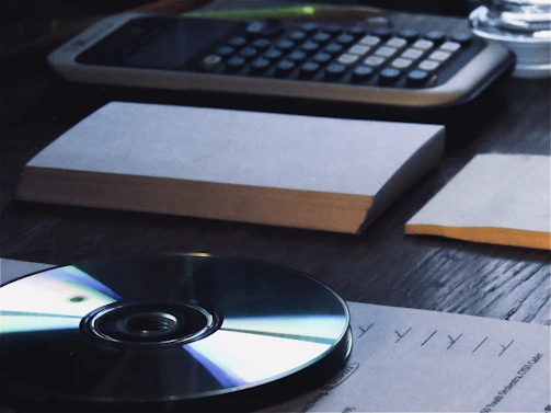 A professional accountant reviewing financial documents with a laptop and calculator on a wooden desk.