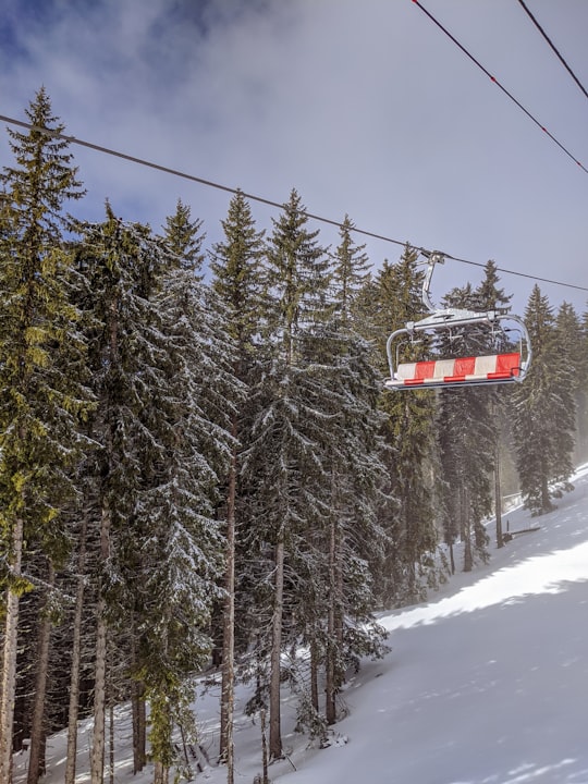 red cable car over snow covered pine trees under blue sky during daytime in Morzine France