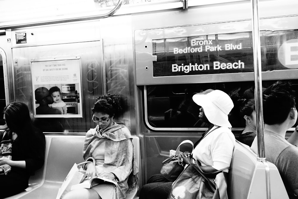 Donna in cappotto bianco che si siede sul sedile del treno