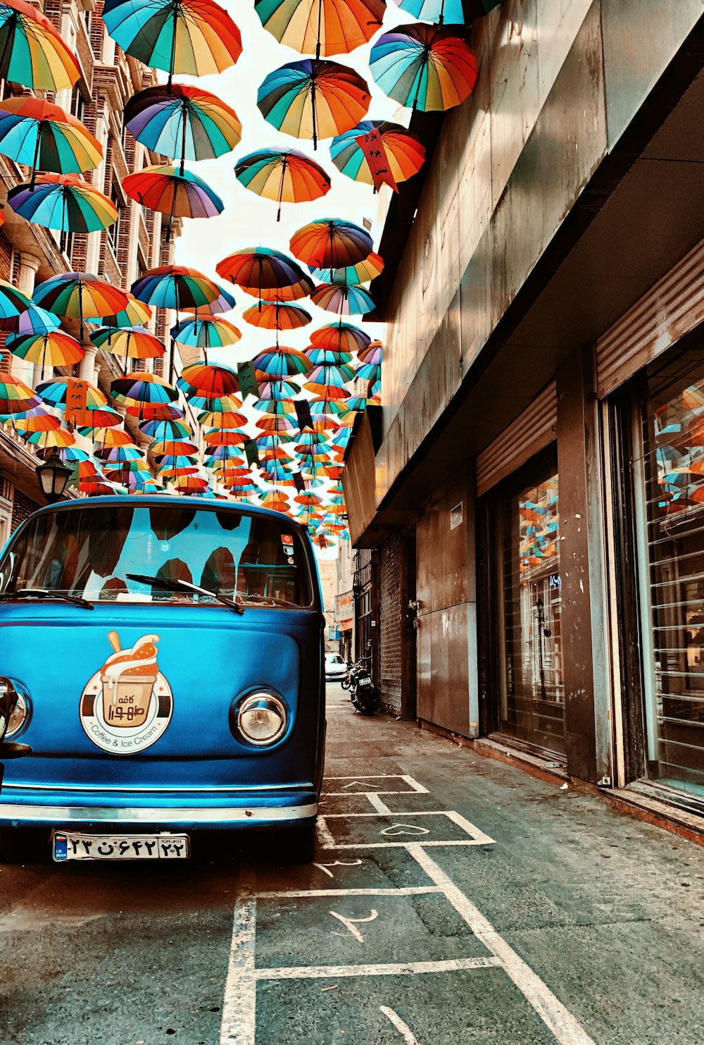 blue volkswagen t-2 parked beside building during daytime