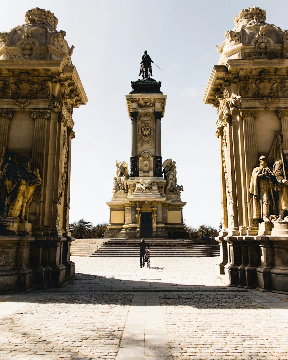 man in black jacket standing in front of statue