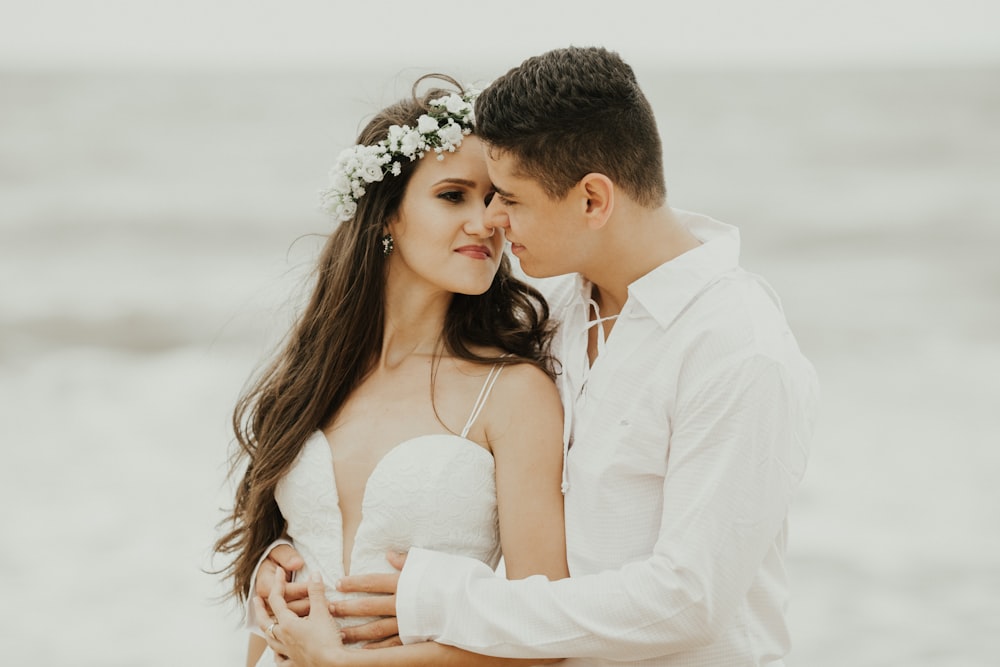 man in white dress shirt kissing woman in white dress