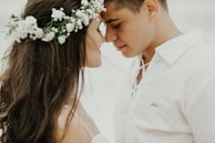 woman in white dress shirt kissing mans cheek