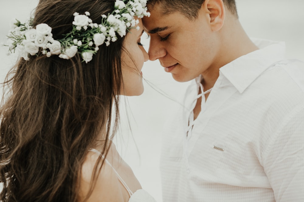 woman in white dress shirt kissing mans cheek