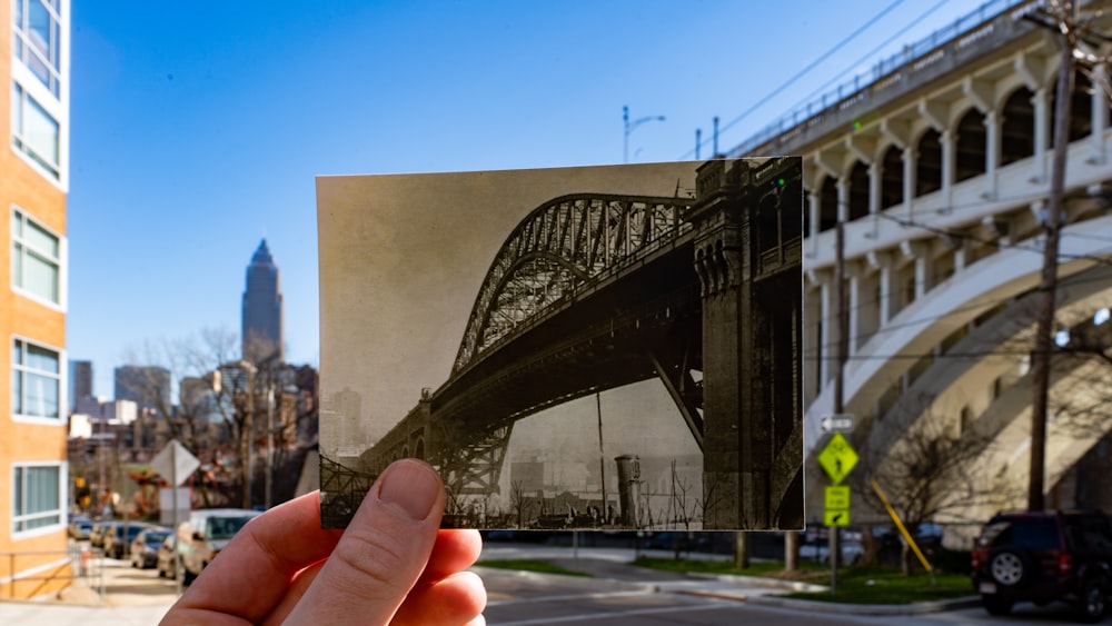 person holding photo of bridge