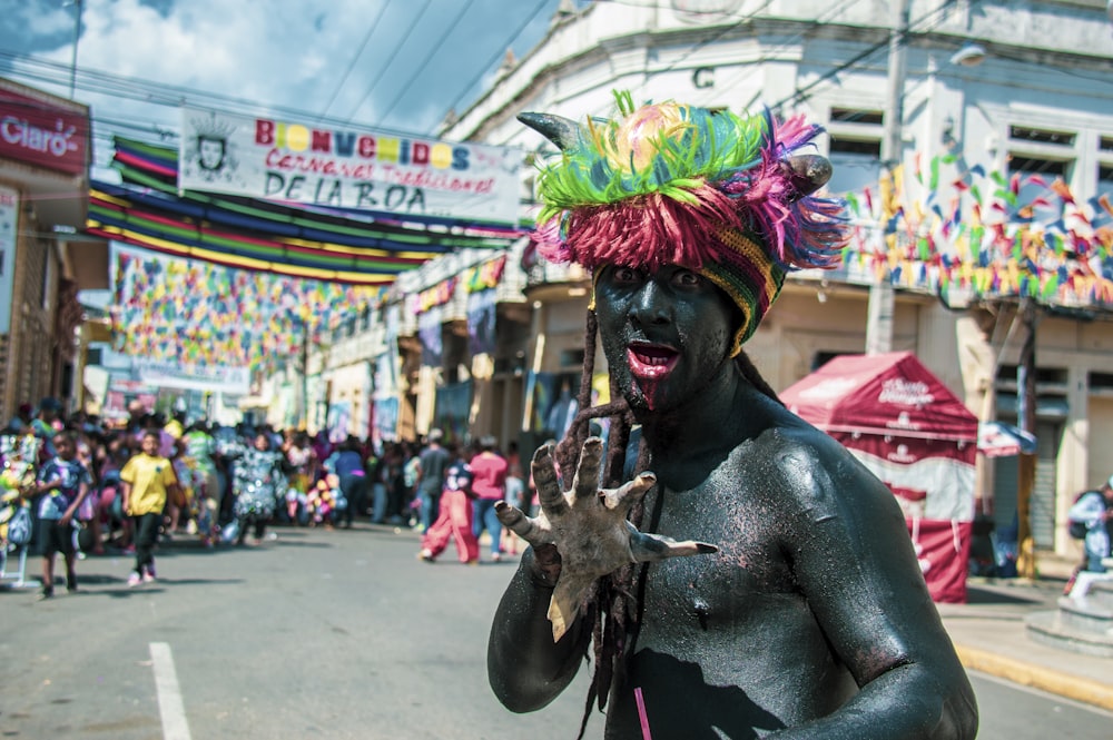 man with yellow green and pink feather headdress