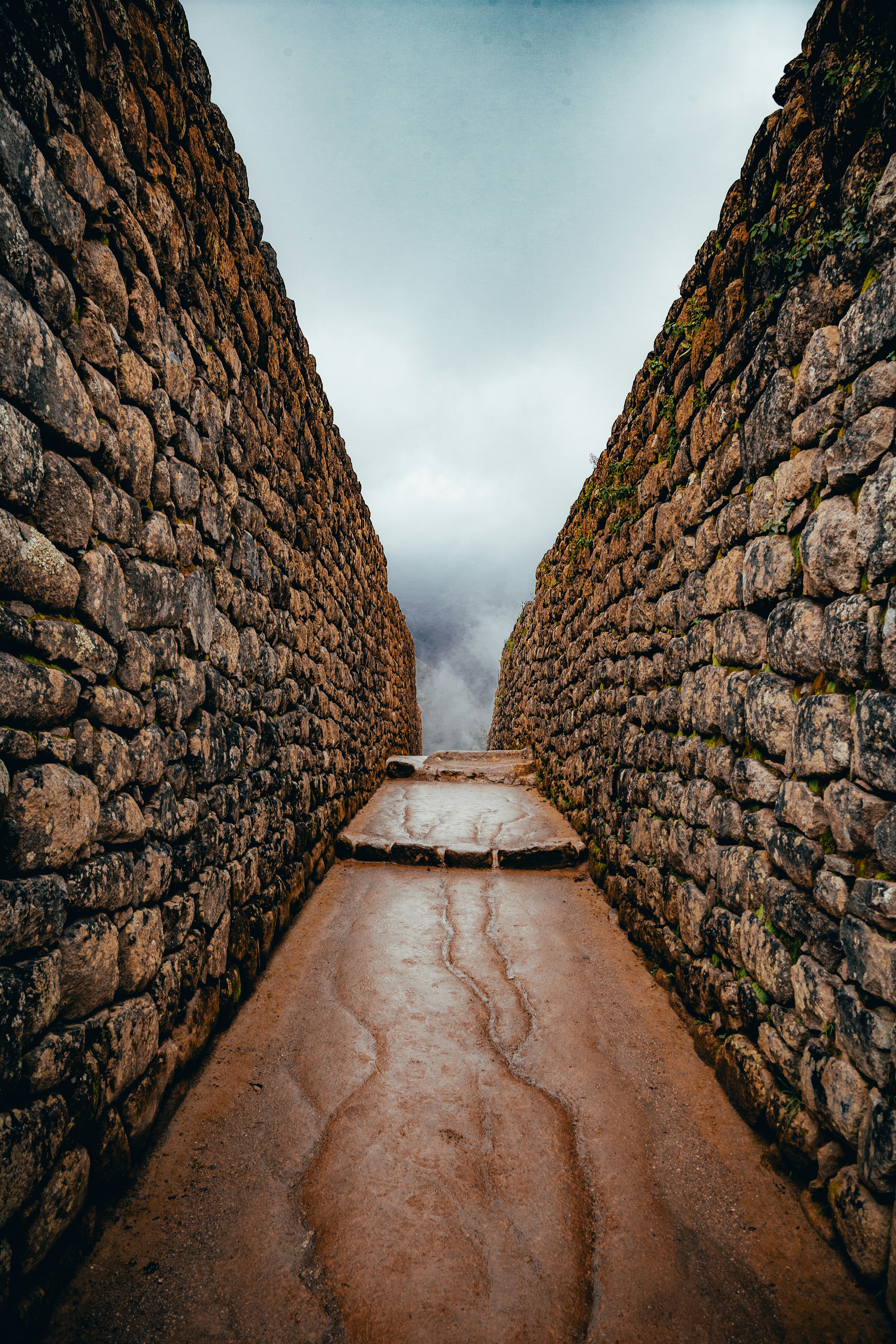 brown pathway between gray rocks