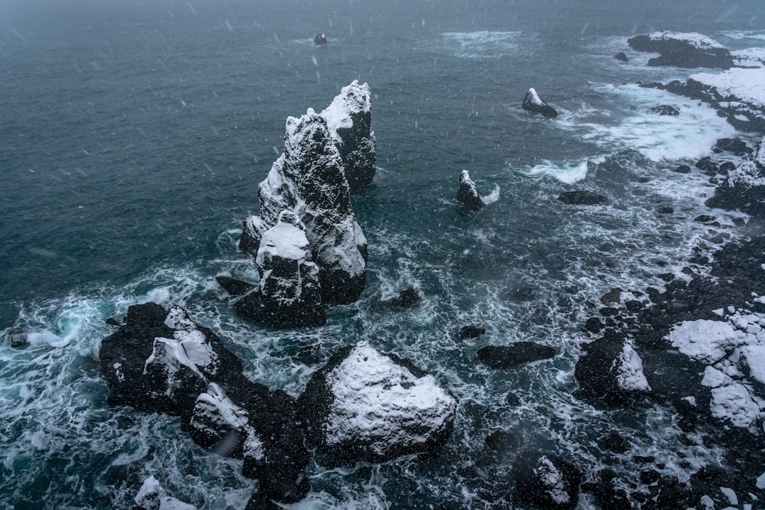 black and white rock formation on body of water during daytime