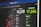 A digital screen displays pandemic statistics with total deaths and total recovered numbers prominently featured. Several locations are listed with corresponding figures. The layout uses contrasting colors to differentiate between the data types.