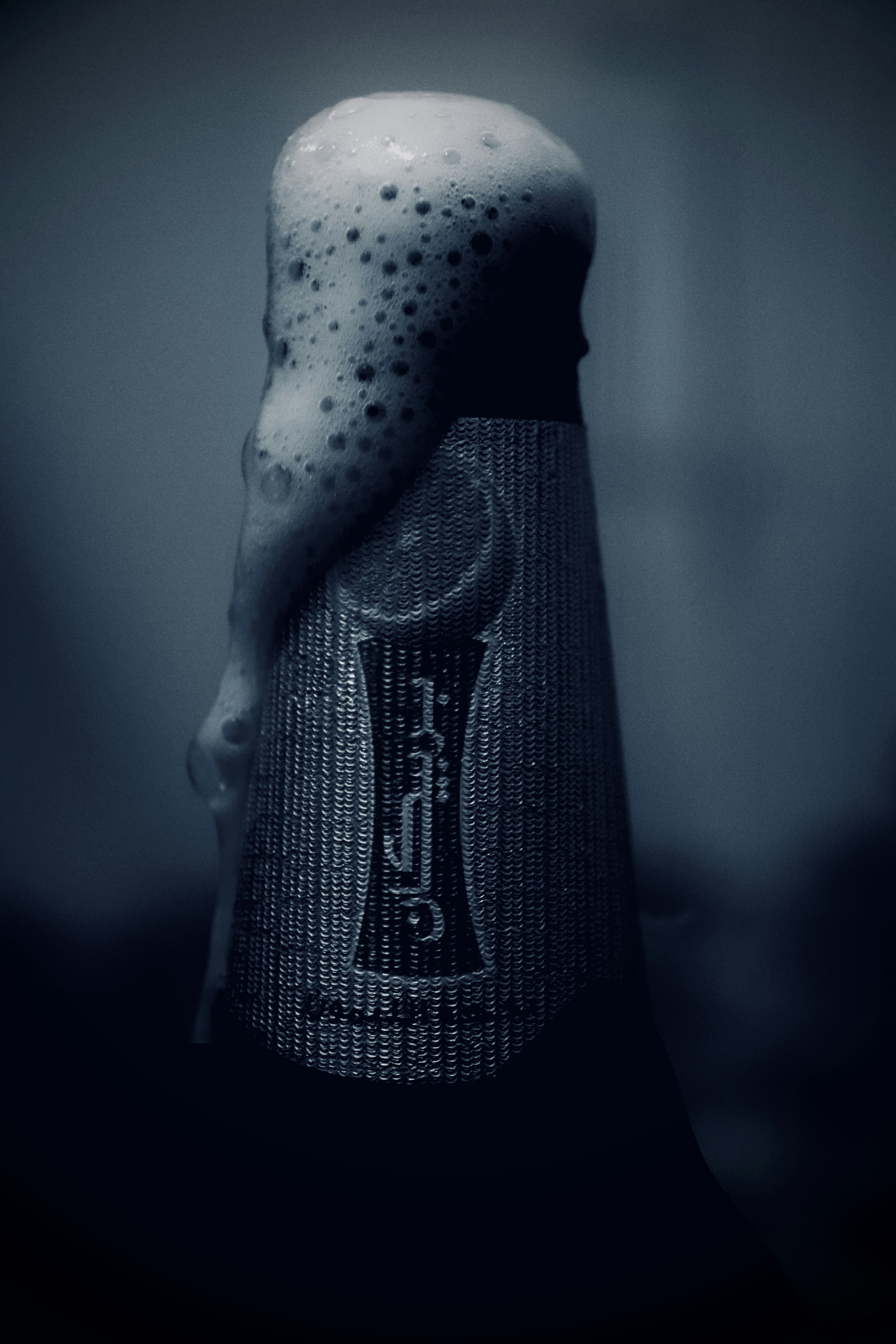 Champagne bottle being uncorked with dramatic spray, dark moody background with gold light