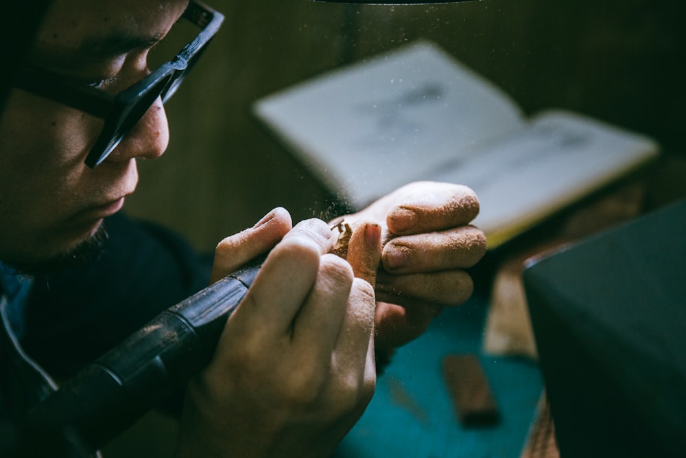 man in black framed eyeglasses holding black smartphone