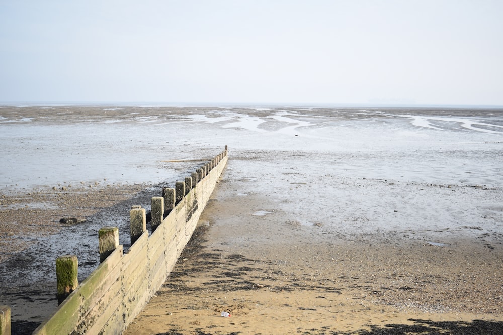 brown wooden fence on beach during daytime